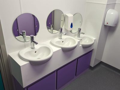 a bathroom with three sinks and three mirrors