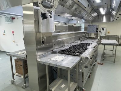 a commercial kitchen with stainless steel appliances, hobs and counters