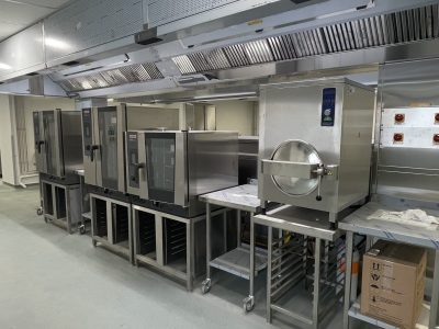 a commercial kitchen with stainless steel appliances, ovens and counters